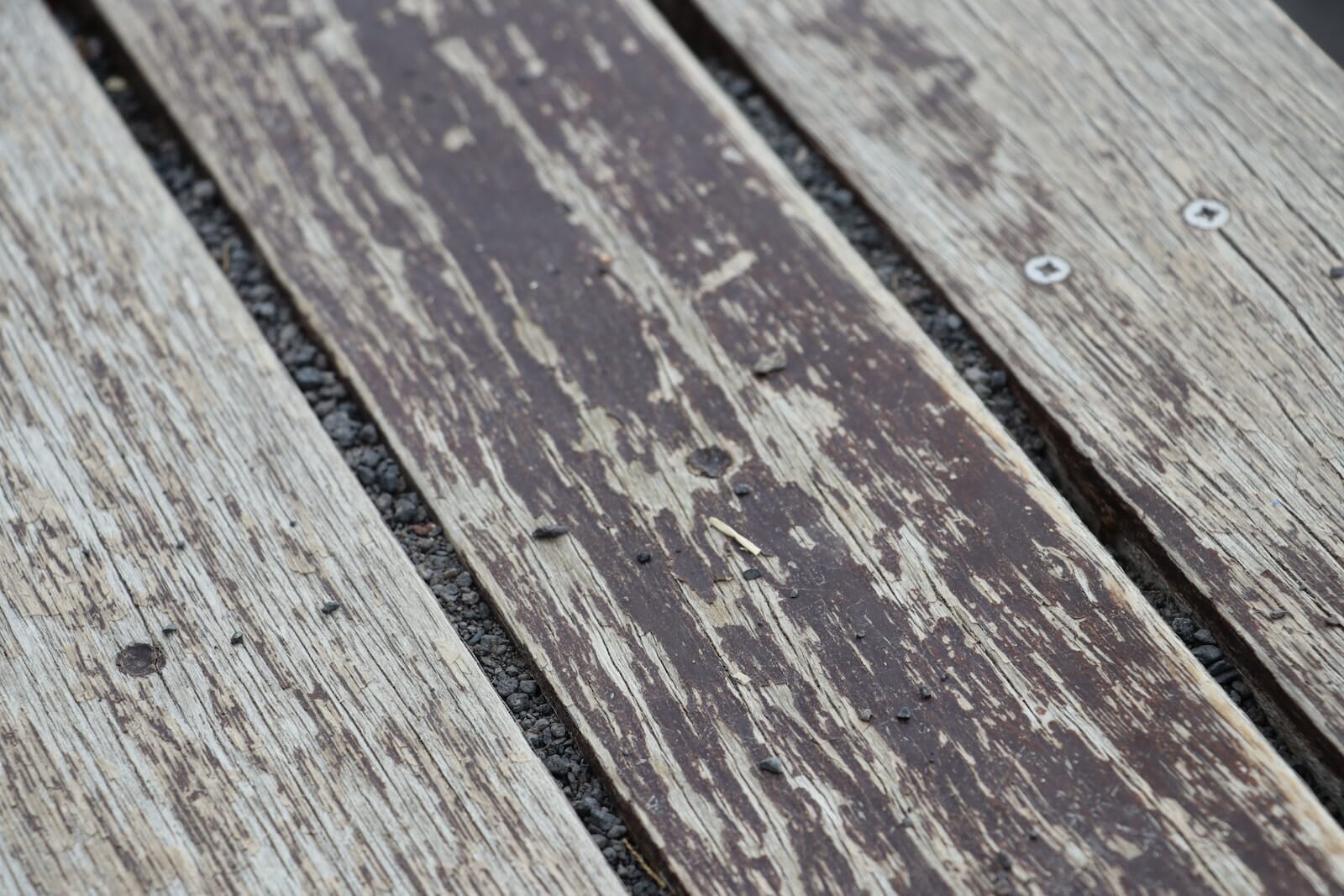 a close up of a wooden bench with nails on it